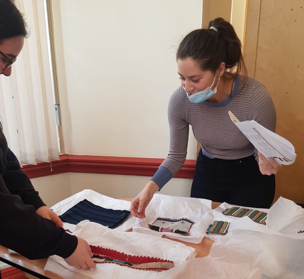 Maria Marquez, Curatorial Associate, wearing a face mask and sorting through collections items.