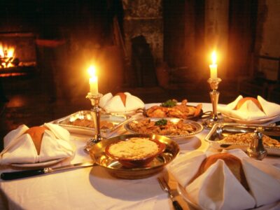 A historic meal laid out on a table and lit by candlelight
