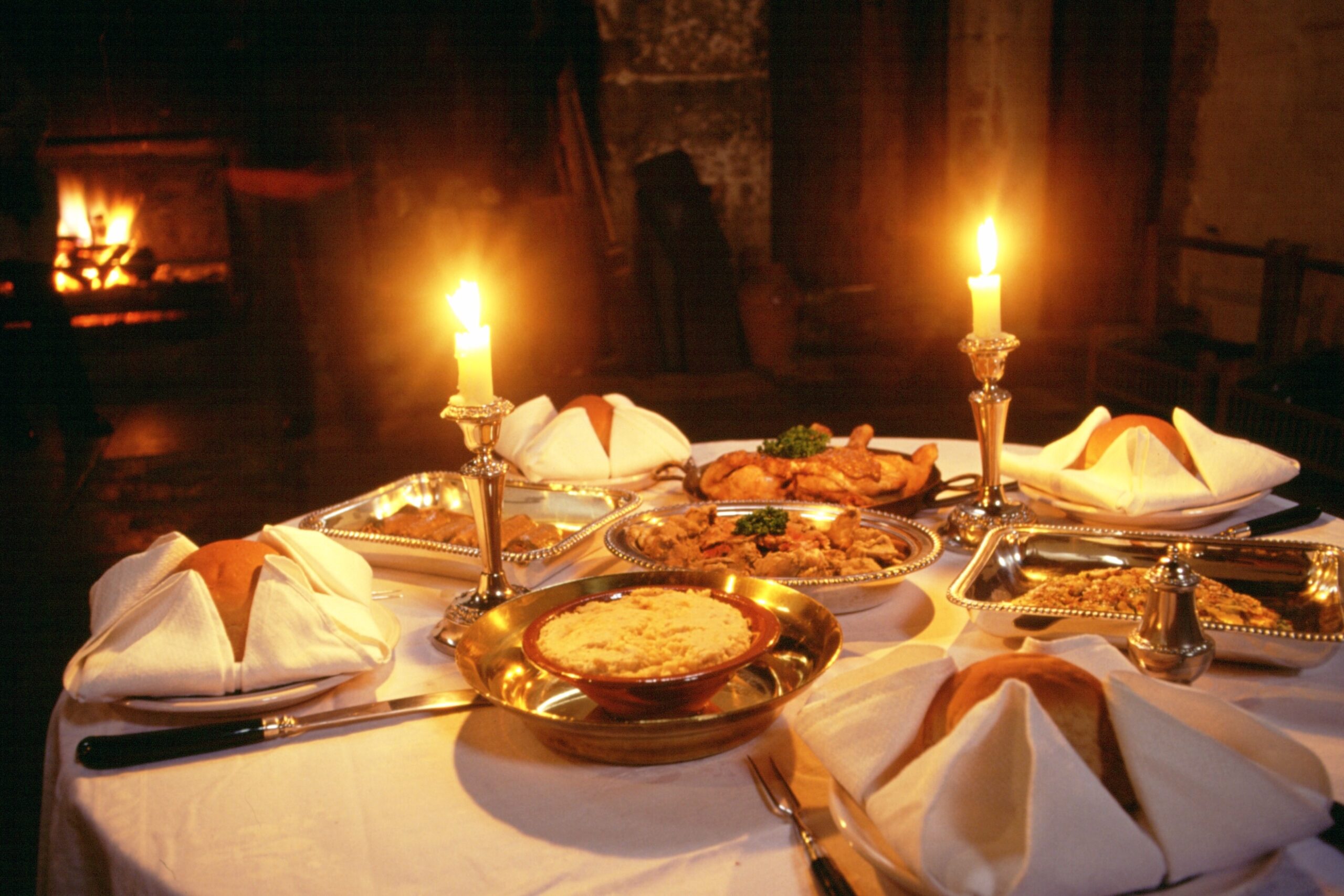 A historic meal laid out on a table and lit by candlelight